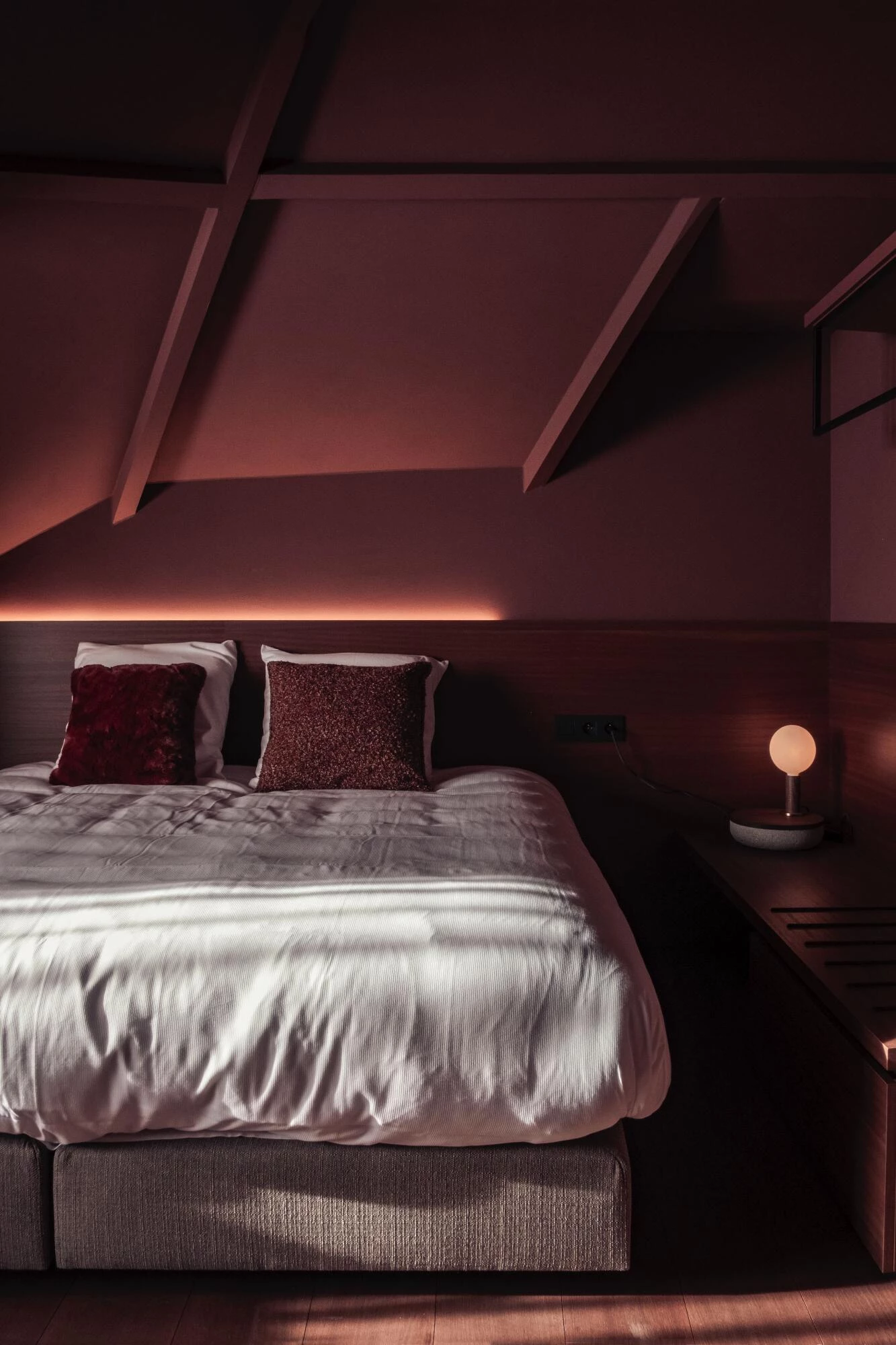 Slaapkamer met diepe kleurtinten en houtaccenten
